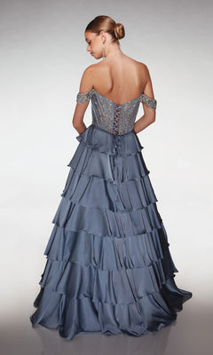 A woman stands with her back to the camera against a neutral background, wearing the Alyce 62035 long prom dress featuring an off-shoulder beaded corset bodice and a satin tiered skirt.