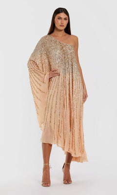 A woman wearing the Tea-Length Party Dress: Mac Duggal 6204 in champagne gold, featuring a one-shoulder neckline, knee-length hem, elegant gold sequin embellishments, and a draped sleeve stands against a white background—an exquisite look that showcases signature Mac Duggal elegance.