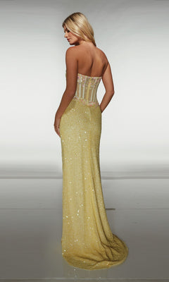 A woman faces away from the camera in an Alyce 62047 long prom dress, featuring a strapless yellow floor-length design with a fitted bodice, sheer back panel, and sequin wrap-style skirt against a plain background.