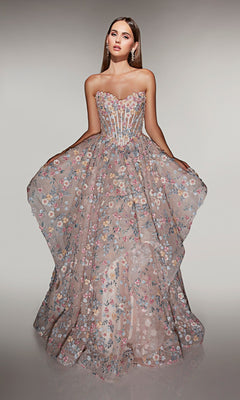 A woman wears the Alyce 62048 long prom dress, featuring a strapless sheer corset bodice and voluminous skirt adorned with floral appliques as she gracefully extends its sides.