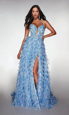 A woman stands against a plain, light background wearing the Alyce 62052 long prom dress, a light blue gown with a corset bodice, ruffle A-line skirt, and thigh-high slit.
