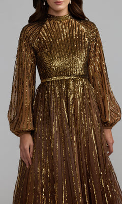 A woman wearing the Mac Duggal 6206 Blue Ombre Sequin Formal Gown, which features long sleeves, a high neckline, and elegant pleated detailing. The upper half of her body is visible, showcasing the shimmering blue ombre sequins on the dress.