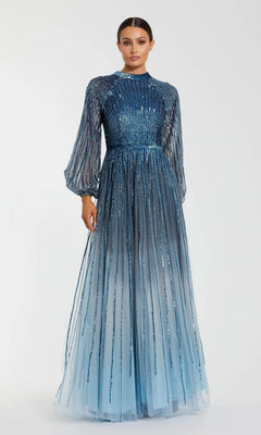 A woman wears the Mac Duggal 6206 long formal dress, a blue ombre sequin gown with sheer long sleeves and vertical sequin detailing, standing against a plain white background.