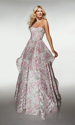 A woman poses in the Alyce 62071 Long Prom Dress, a strapless organza ball gown with a pastel floral pattern and a layered, flowing skirt, set against a plain background.