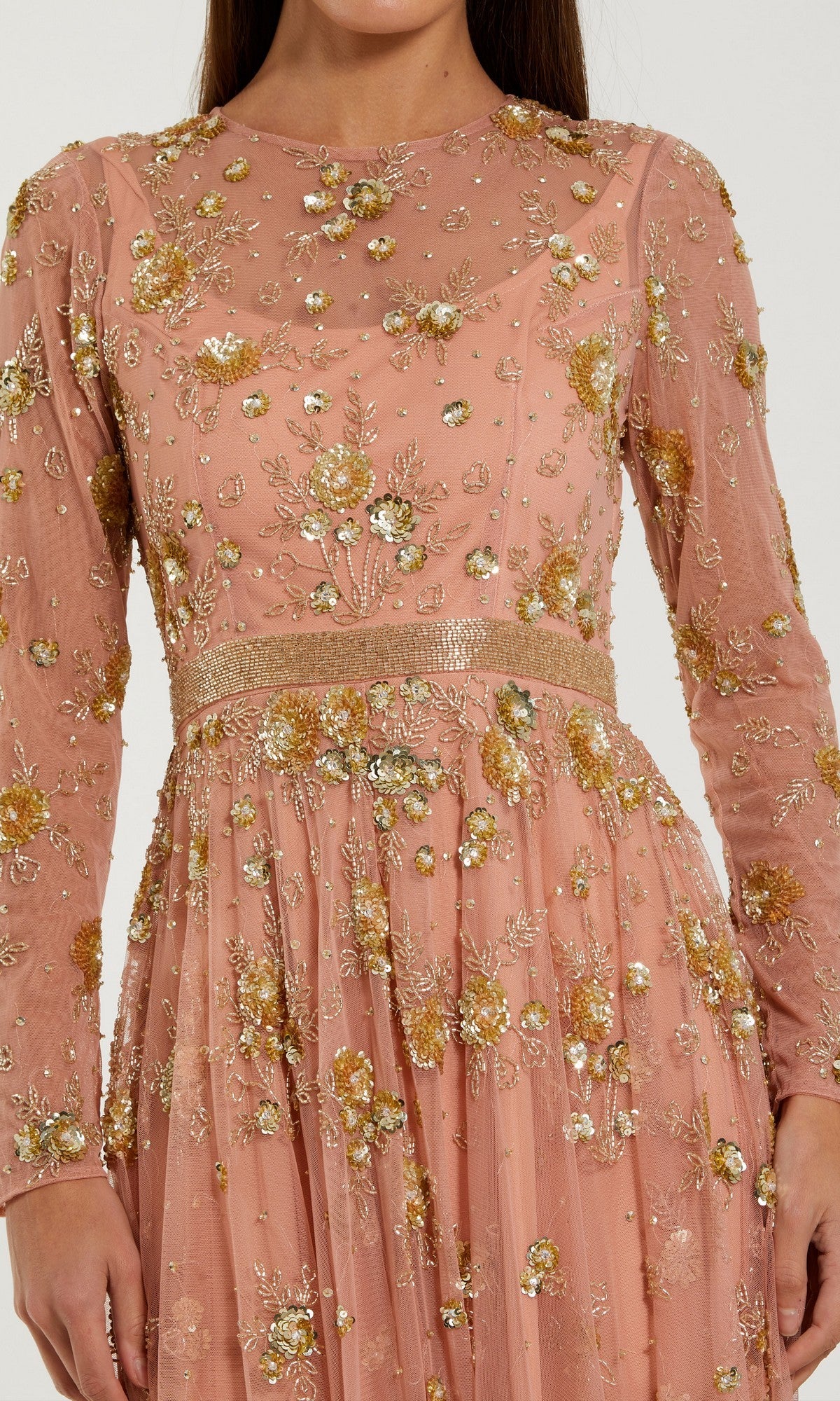 A woman wearing the Mac Duggal 6208 Tea-Length Party Dress—a long-sleeved peach floral dress adorned with gold embroidery and elegant embellishments, making it an ideal choice for a wedding guest.