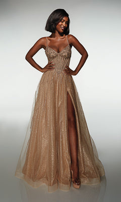 A woman smiles with her hands on her hips, wearing the Alyce 62093 long gold prom dress with thin straps and a high leg slit, standing against a plain background.