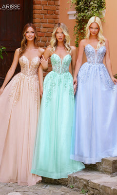 Three women pose outdoors in pastel Clarisse Designs 62102 prom ball gowns, featuring strapless beaded floral lace bodices and glitter tulle skirts, standing side by side before a brick wall and peach building.