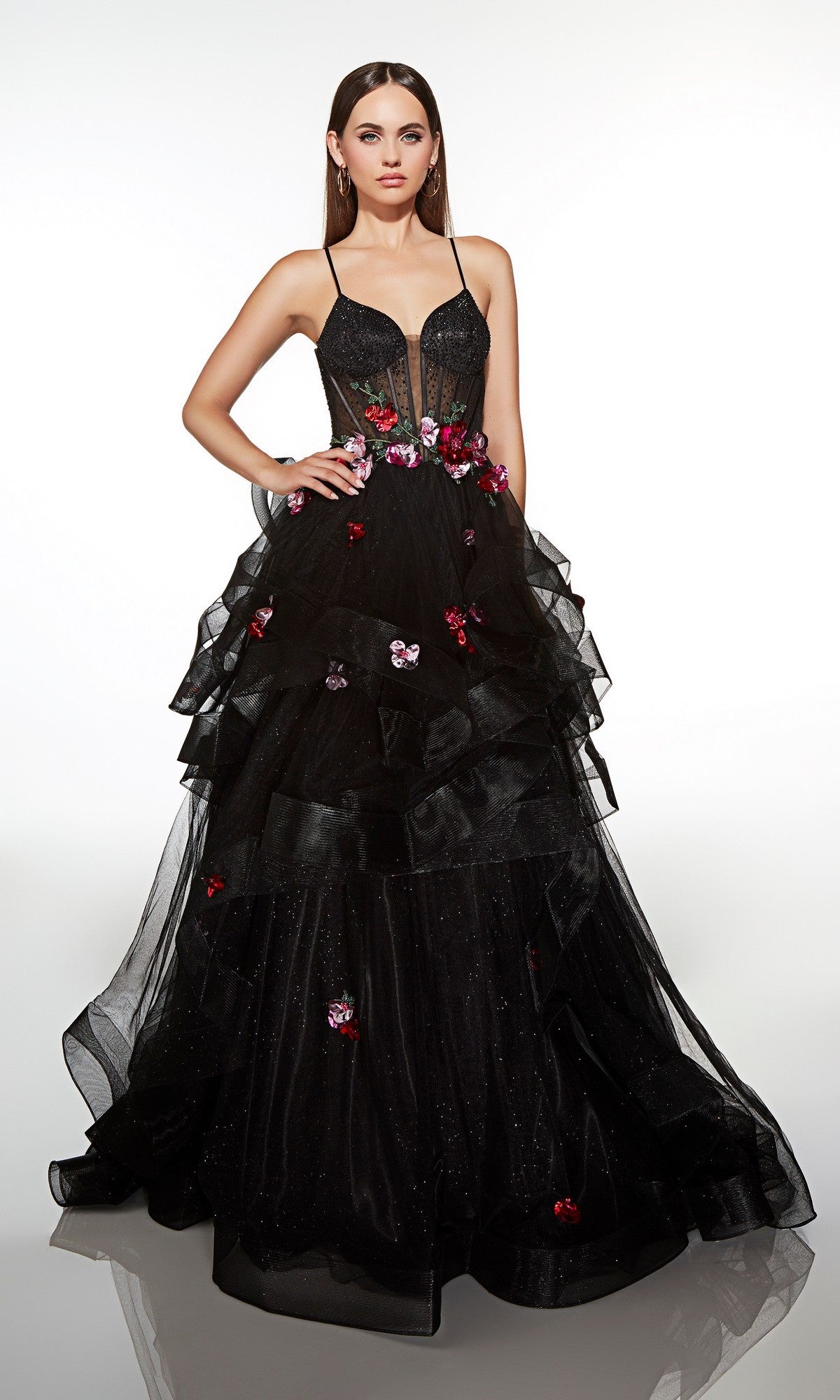 A woman in the Alyce 62108 long prom dress, featuring a black/multi floral corset bodice, thin straps, and a tulle ruffle skirt, poses against a plain white background.