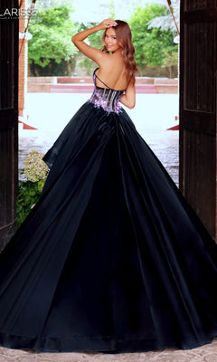 A woman wearing the Clarisse Designs 62110 long prom dress, featuring a strapless ballgown silhouette and floral-embroidered corset bodice, stands in a doorway, glancing over her shoulder with a smile.