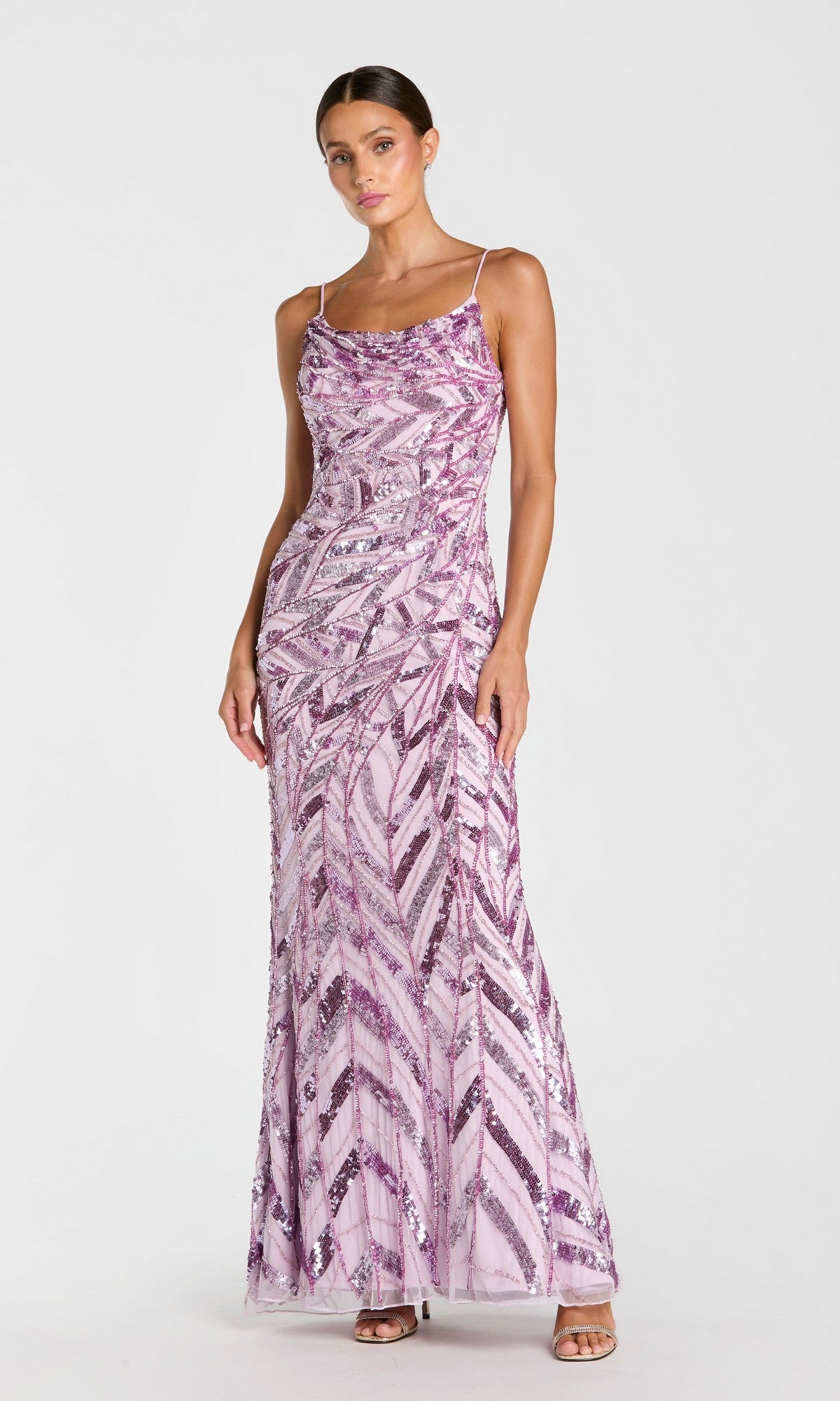 A woman models the Mac Duggal 6214 Long Formal Dress in shimmering lilac, a sleeveless gown adorned with intricate sequin patterns and a graceful cowl neckline. She stands against a plain white background, effortlessly embodying its sophisticated elegance.