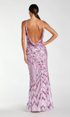 A woman stands with her back to the camera, showcasing the Long Formal Dress: Mac Duggal 6214—a floor-length, backless gown adorned with pink sequins, featuring thin straps and a striking geometric pattern. This glamorous dress effortlessly combines sparkling embellishments with refined elegance for an unforgettable look.