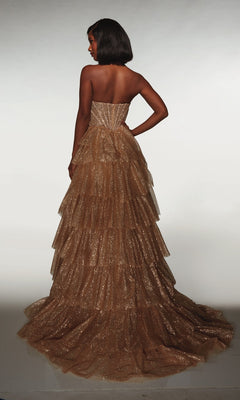 A woman wearing the Alyce 62144 long formal dress featuring a gold, glittery tiered ruffle skirt stands with one hand on her hip, facing away against a plain background.