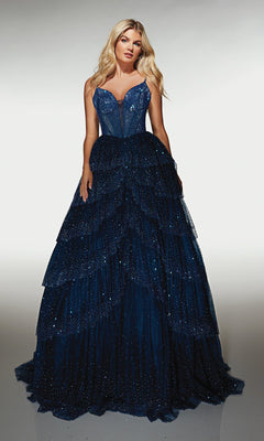 A woman stands against a plain background wearing the Alyce 62146, a navy long formal dress with a sleeveless beaded corset bodice and a tiered ruffle ball gown skirt.
