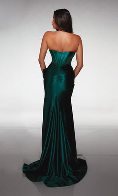 A woman stands with her back to the camera wearing the Alyce 62156, a strapless emerald green satin formal dress featuring a fitted bodice, beaded sweetheart neckline, and long flowing train.