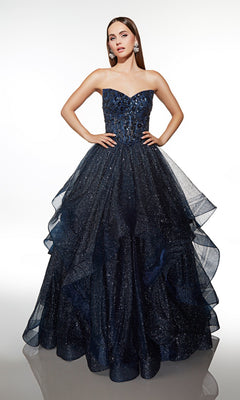 A woman stands against a plain white background wearing the Alyce 62173 long formal dress—a strapless, navy blue ball gown with a fitted bodice and layered glitter tulle skirt.