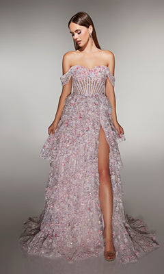 A woman wears the Long Prom Dress: Alyce 62186 in pink, featuring a strapless A-line design with high slit, sheer corset bodice, and 3D floral appliques, standing against a neutral background.