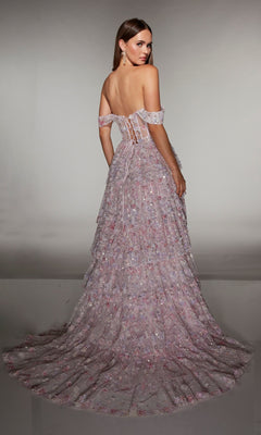 A woman poses with her back to the camera in the Alyce 62186 long prom dress, showcasing its lace-up back, pastel pink and purple a-line skirt, off-the-shoulder neckline, 3D floral appliques, and layered train.