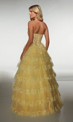 A woman stands facing away on a plain background, wearing the Alyce 62191 long prom dress, which features a strapless bodice, tulle A-line skirt, and floral embroidery.