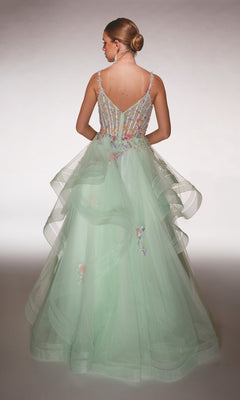 Woman with her back to the camera wears the Alyce 62201 Long Formal Dress in light green, featuring a layered tulle skirt and 3D floral appliques. Her hair is styled in a low bun.