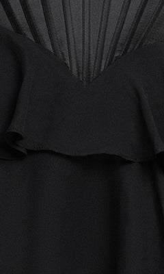 Close-up of the Ruffled Mini Hoco Dress: Blondie Nites 6222BN—a black corset mini dress with a ruffled layer and fan-patterned vertical stitched lines at the top.