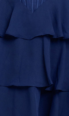 Close-up of layered navy blue fabric with ruffled edges and pleated texture from the Ruffled Mini Hoco Dress: Blondie Nites 6222BN, highlighting details of this short homecoming dress.