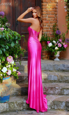 A woman stands on stone steps among flowers and greenery, wearing a shiny bright pink Long Prom Dress: Clarisse Designs 62241; a brick wall is in the background.