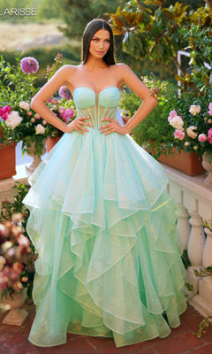 A woman stands on a flower-filled balcony wearing the Clarisse Designs 62263 Prom Ball Gown in Glitter Mint, featuring a strapless fitted bodice and ruffled tulle skirt.