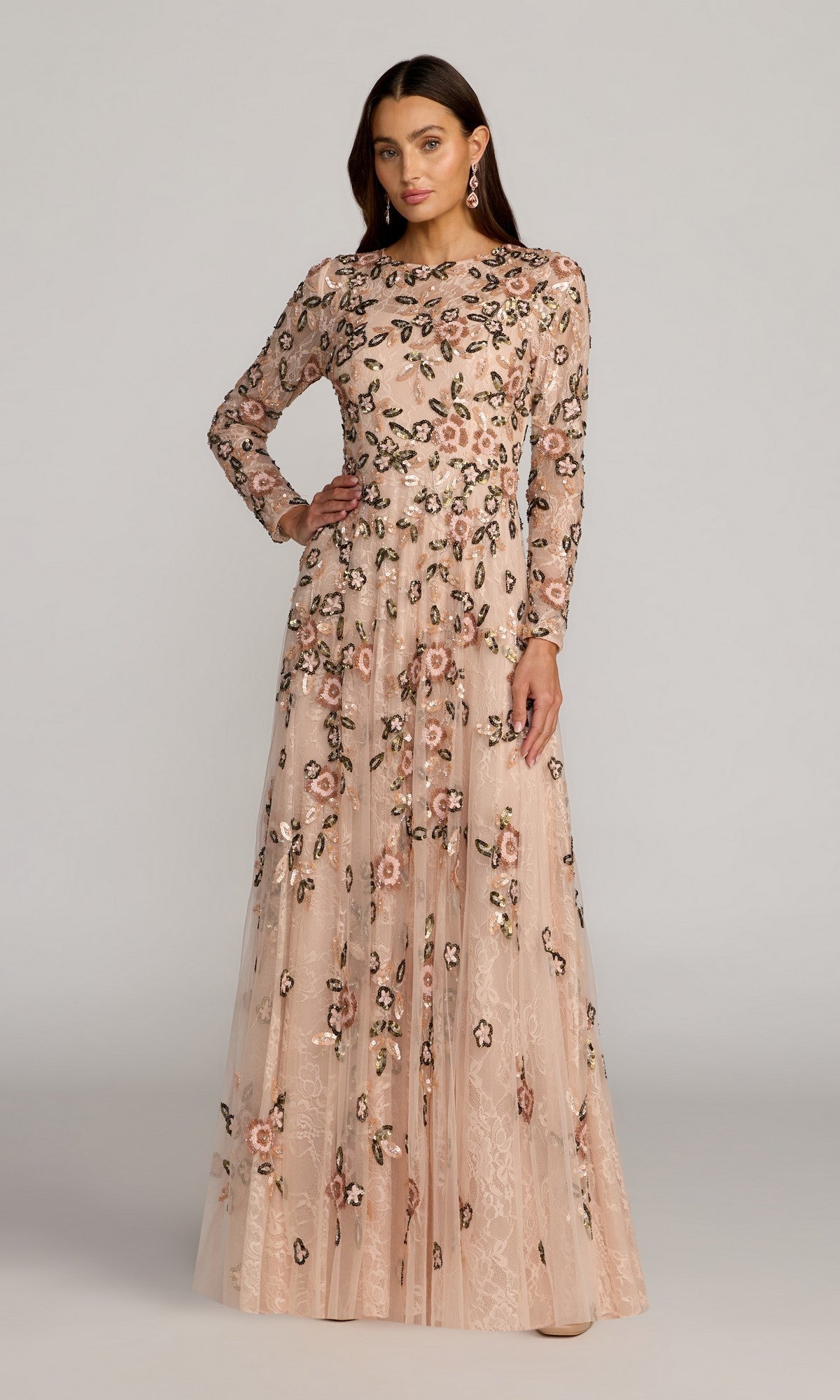 A woman poses in the Mac Duggal 6239 Long Formal Dress in Rose Multi, featuring intricate floral embroidery and delicate lace sequin detailing, standing against a plain light grey background.
