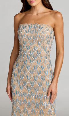 Wearing the Mac Duggal 6250, a strapless nude long formal dress featuring blue and silver sequin patterns, the woman stands against a plain background.