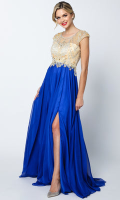 A woman models the Juliet 636 long prom dress featuring a royal blue sheer back, gold embellished bodice, cap sleeves, an a-line skirt with a thigh-high slit, standing against a plain background.