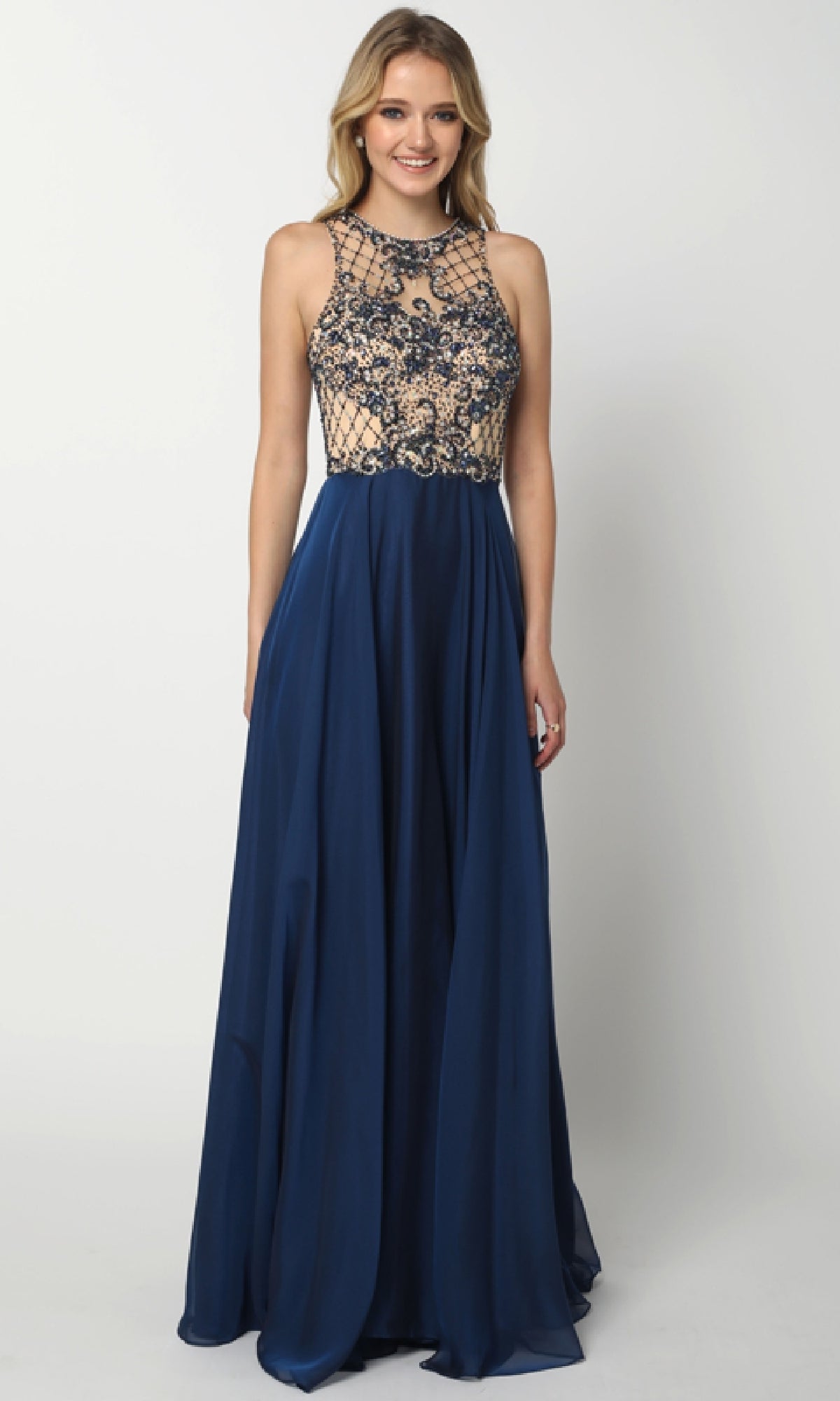 A woman wears the Juliet 637 Long Prom Dress, showcasing a sleeveless navy blue embellished bodice, flowing skirt, and subtle low-back cutout against a plain background.