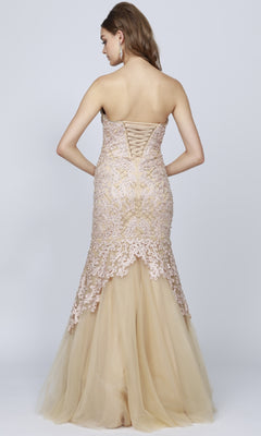 A woman wearing the Juliet 644 Long Mermaid Prom Dress—strapless, floor-length beige with lace details and a lace-up back—stands against a plain light background, ideal for prom or formal events.