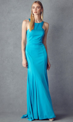 A woman poses against a gray backdrop wearing the Juliet 645, a sleeveless, floor-length turquoise prom dress with a racer front, paired with statement earrings.