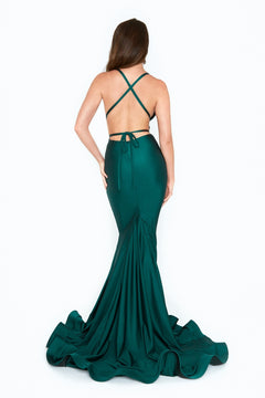 A woman stands against a white background wearing the emerald green Strappy-Back Long Mermaid Prom Dress (Atria 6530H) with crisscross straps and a flared train.