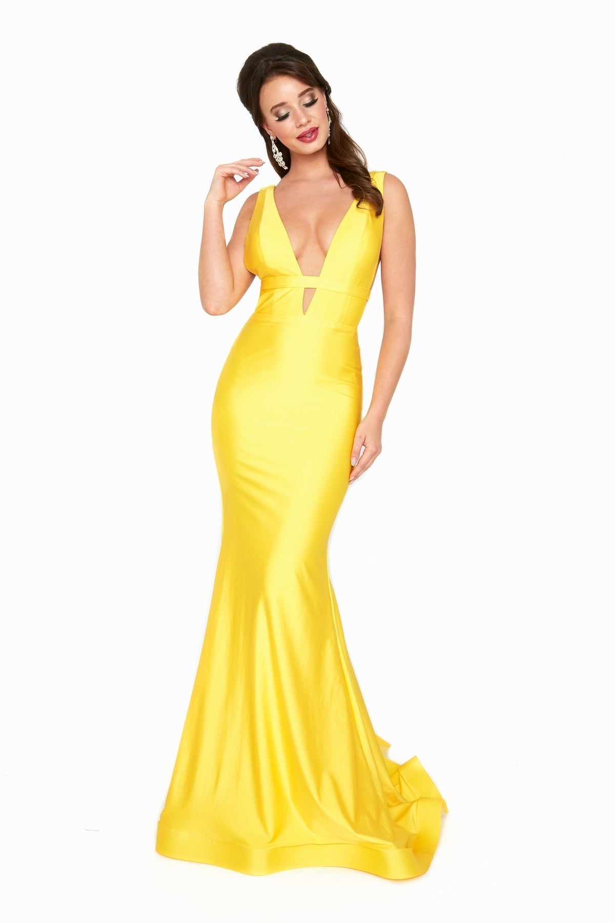 A woman wearing the Atria 6539H Waistband Deep V-Neck Long Prom Dress, a sleeveless yellow mermaid gown, stands against a white background.