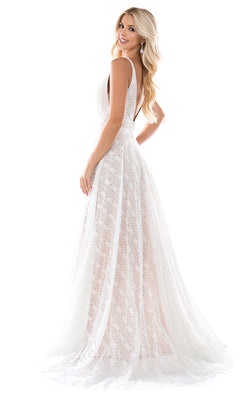 A woman with long blonde hair models the Nina Canacci 6553, a sleeveless, floor-length white lace dress with a plunging V-neckline and deep V-back, posed against a plain white background.