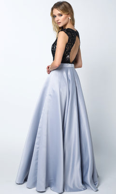 Woman modeling the Juliet 661 Cut-Out Long A-Line Prom Dress, featuring a black lace open-back top and light gray satin skirt, standing and glancing over her shoulder.