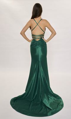 A woman in the Nina Canacci 6632 long formal dress, a shimmery green mermaid gown with spaghetti straps and a strappy open back, stands against a plain background as the elegant skirt flows to the floor with a slight train.