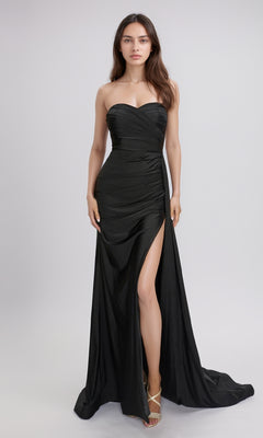 A woman wears the Nina Canacci 6686 long formal dress, featuring a strapless sweetheart neckline and a thigh-high slit, standing against a plain light background.