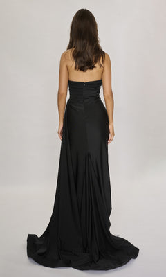 A woman with long brown hair, wearing the Nina Canacci 6686 long formal dress featuring a strapless sweetheart neckline, stands facing away against a plain light background.