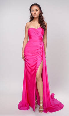 A woman wears the Nina Canacci 6686 Long Formal Dress, a strapless, floor-length bright pink gown with a sweetheart neckline and thigh-high slit, standing out against a plain light background.