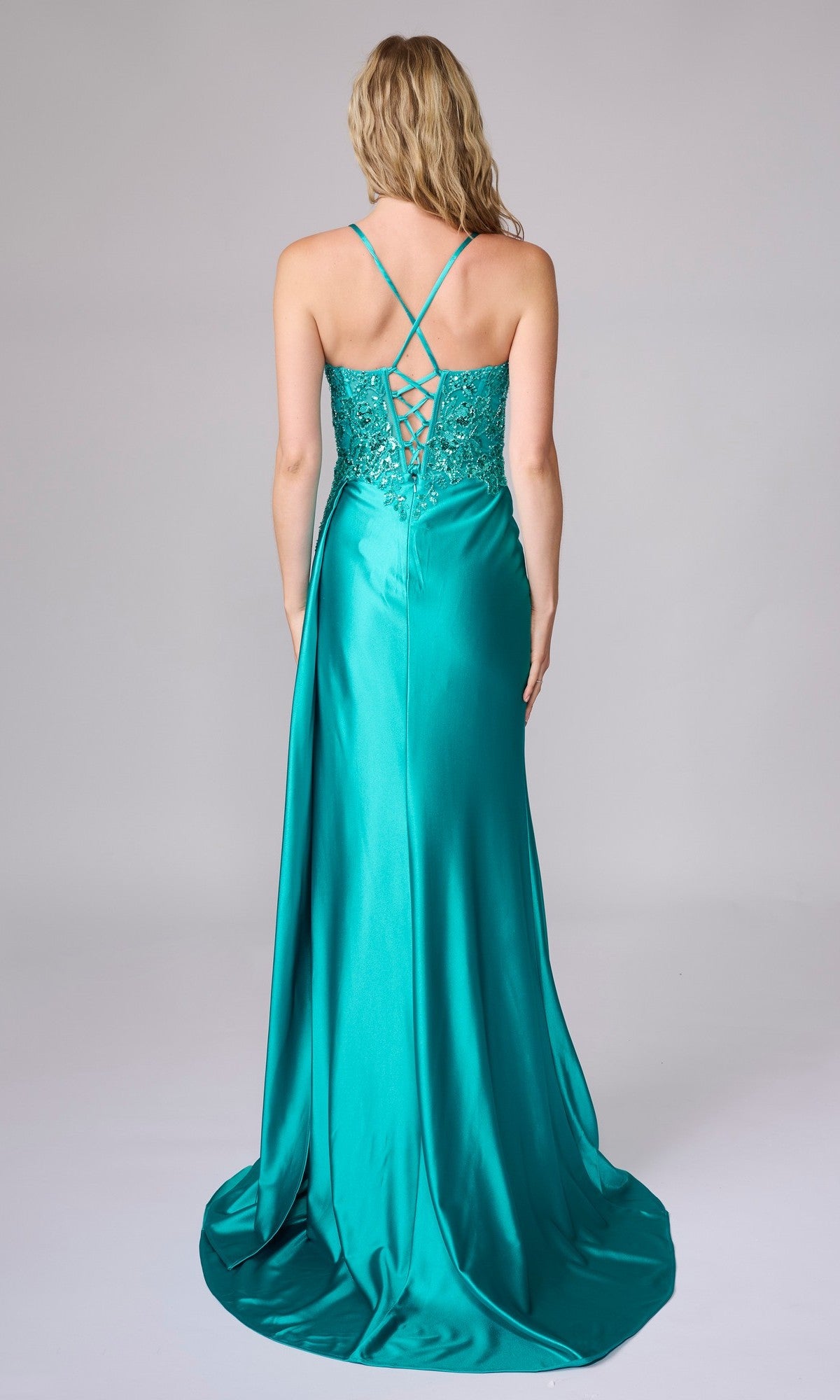A woman faces away, wearing the teal Nina Canacci 6722 long formal dress featuring a lace-up back and thin straps.