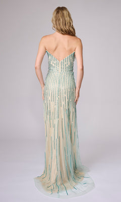 A woman with long blonde hair stands facing away, wearing the Nina Canacci 6723 long formal dress featuring elegant vertical turquoise beading.