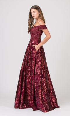 A woman stands against a plain light background wearing the Eureka 6733 long formal dress—an off-the-shoulder, floor-length burgundy gown with a lace-up back, floral pattern, and an embellished bodice.