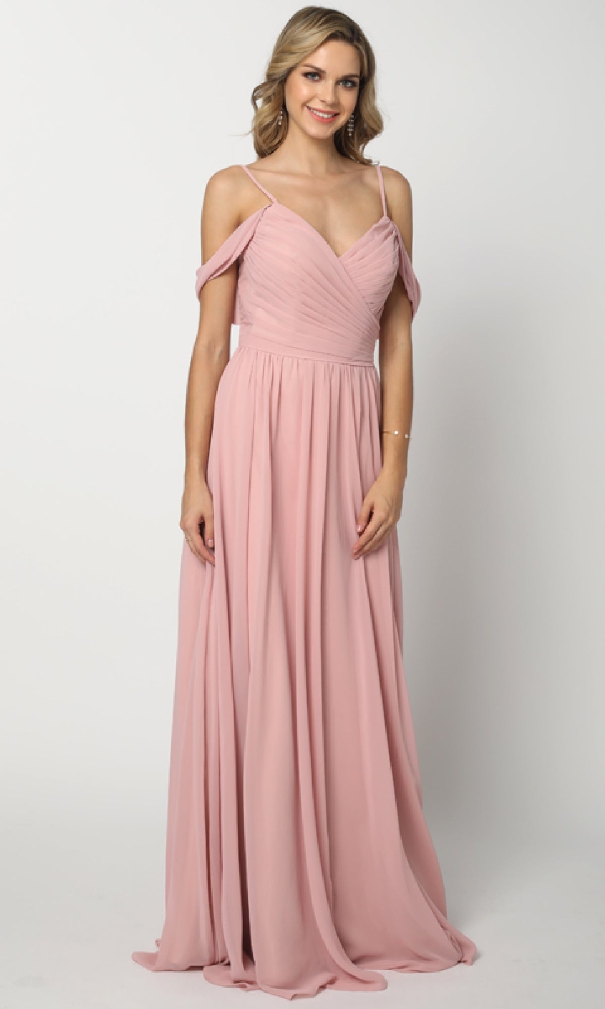 A woman wears the Juliet 676 long prom dress, an off-the-shoulder blush pink chiffon gown with a-line skirt and spaghetti straps, standing against a plain white background.