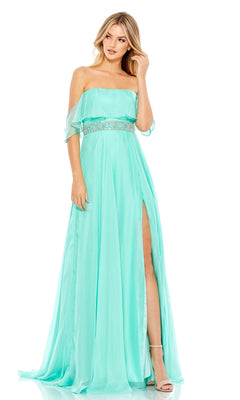 Woman in the Beaded-Waist Off-Shoulder Long Prom Dress 67817, a light blue gown featuring a jeweled waist and high slit, standing with one leg visible and her hand resting on the A-line skirt.
