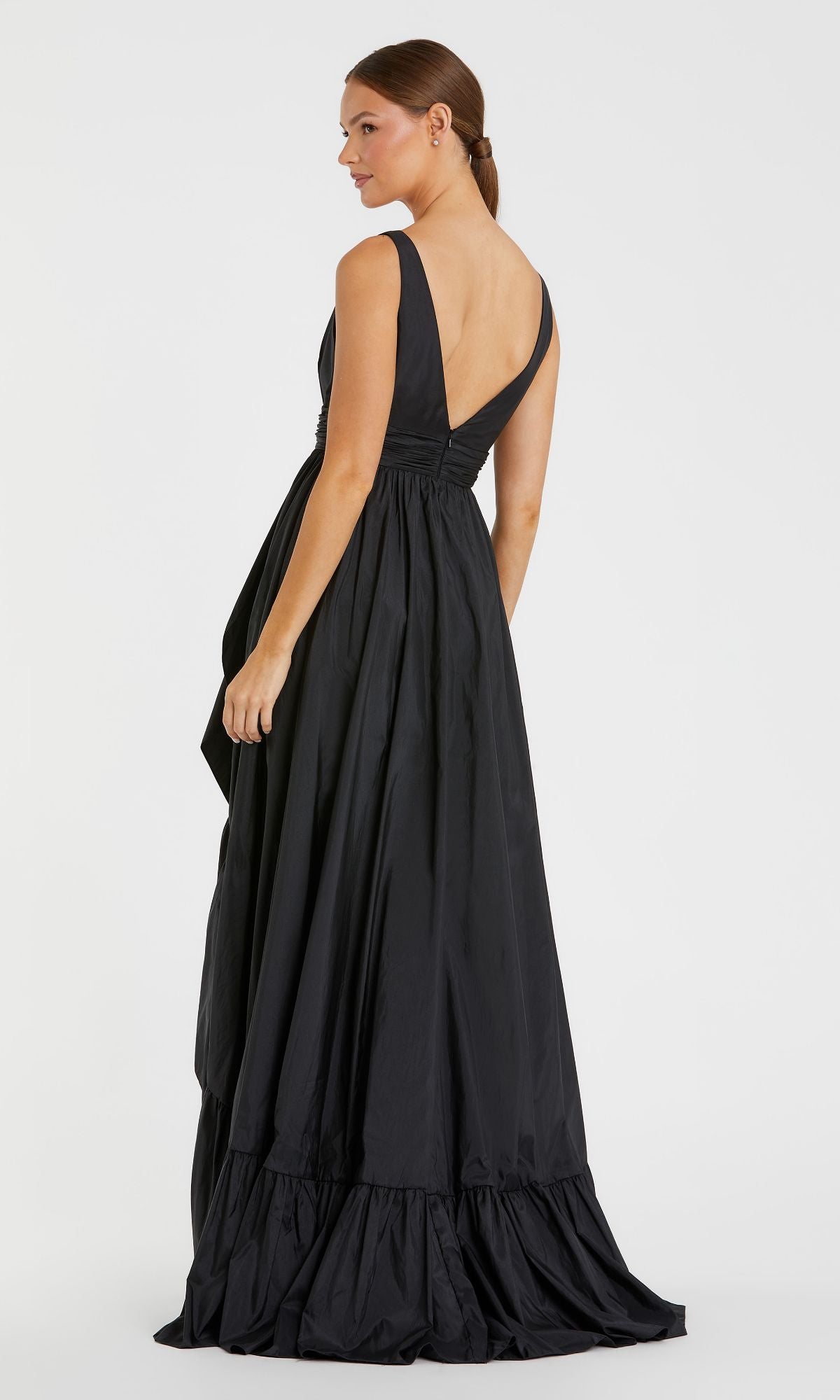 Woman wearing the Mac Duggal 67835 Long Ruffled Formal Dress, a sleeveless black floor-length gown with a V-back, standing and looking to the side against a plain white background.
