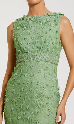 A woman wearing the Mac Duggal 67853 Knee-Length Party Dress, a sleeveless light green lace midi dress with floral appliqué and beading at the waist.