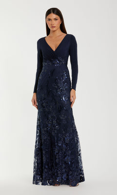 A woman wears the Mac Duggal 67871 Long Sleeve Dark Blue Formal Gown, featuring a V-neckline and sparkling floral sequins.