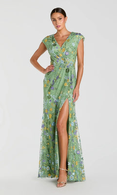 A woman in the Mac Duggal 67882 Cap Sleeve Long Blue Formal Gown stands against a plain light background.
